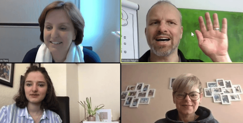 Screenshot of a video conference with four participants, each in their respective home or office environments. Screenshot of a video conference with four participants, each in their respective home or office environments.